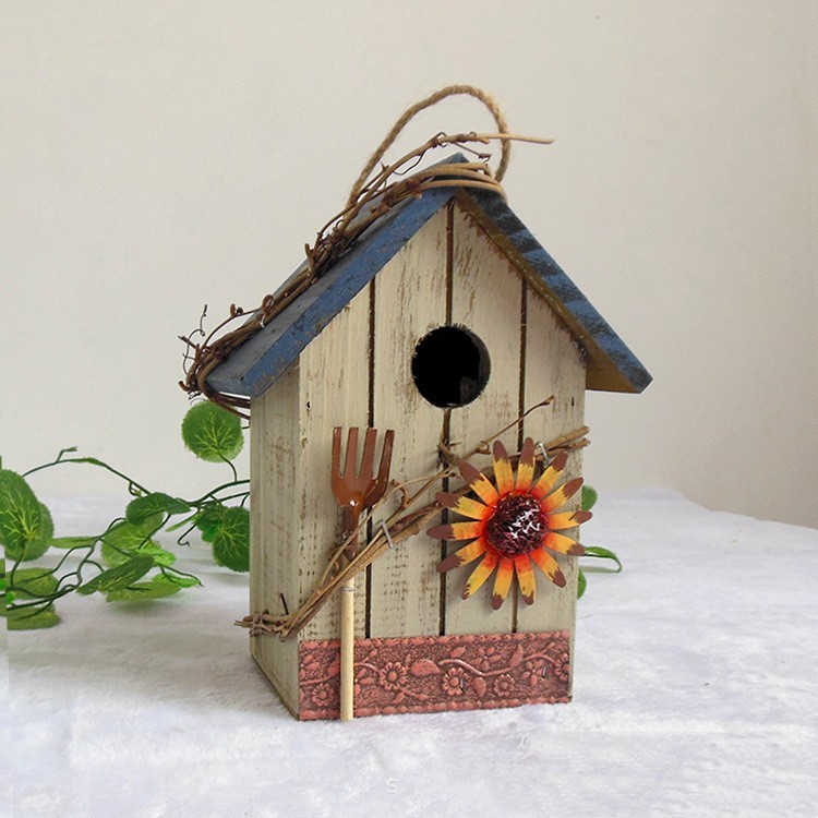Rustic wooden hanging birdhouse painted green with blue roof, flower and garden tool accents - view 8