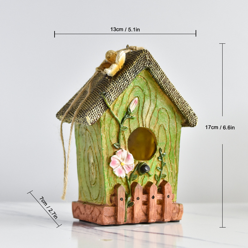 Rustic resin hanging birdhouse in turquoise with orange roof and leaf details hanging in a fig tree - view 4
