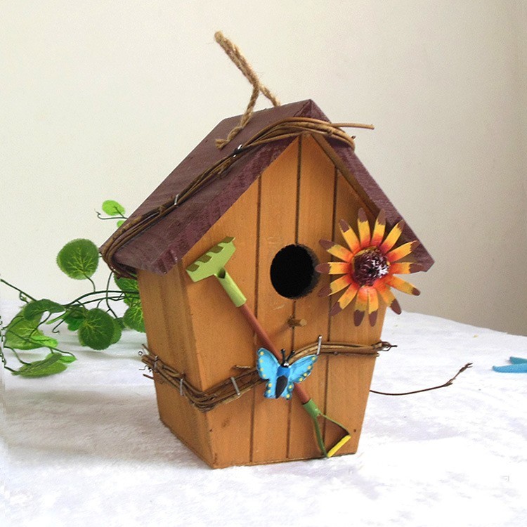 Rustic wooden hanging birdhouse painted green with blue roof, flower and garden tool accents - view 6