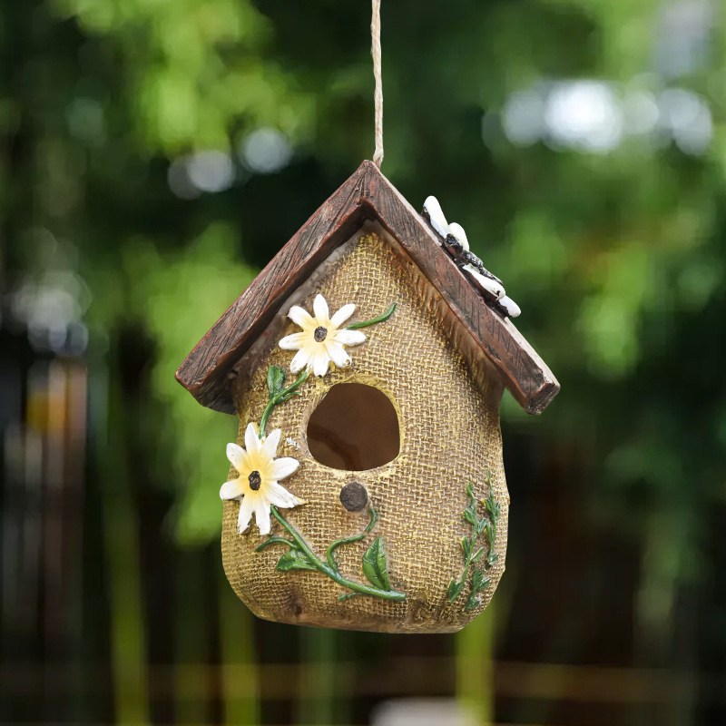 Rustic resin hanging birdhouse in turquoise with orange roof and leaf details hanging in a fig tree - view 8