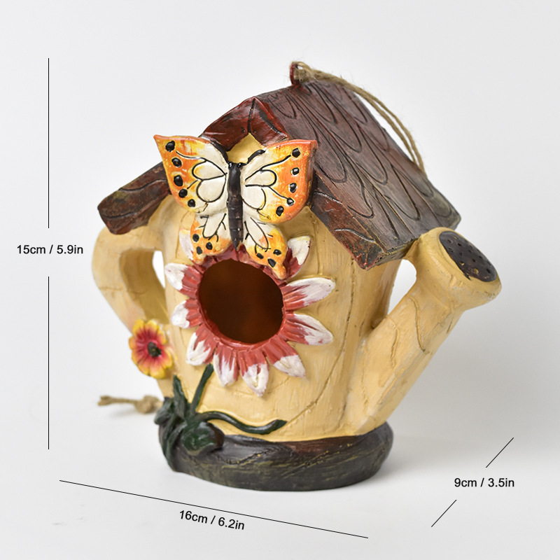 Rustic resin hanging birdhouse in turquoise with orange roof and leaf details hanging in a fig tree - view 5